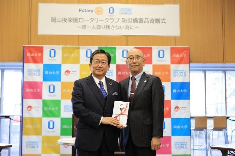 岡村会長（右）から那須理事・副学長への目録贈呈