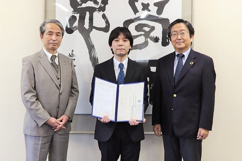 槇野学長（左）より表彰を受けた小島助教、那須理事・副学長（研究担当）