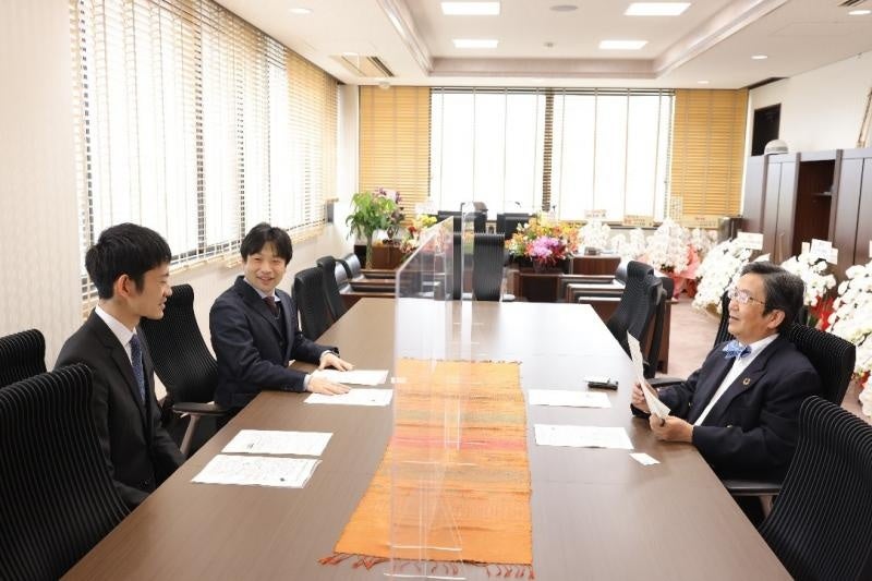 研究内容を那須学長に説明する採択者（右から、那須学長、関本准教授、佐藤助教）