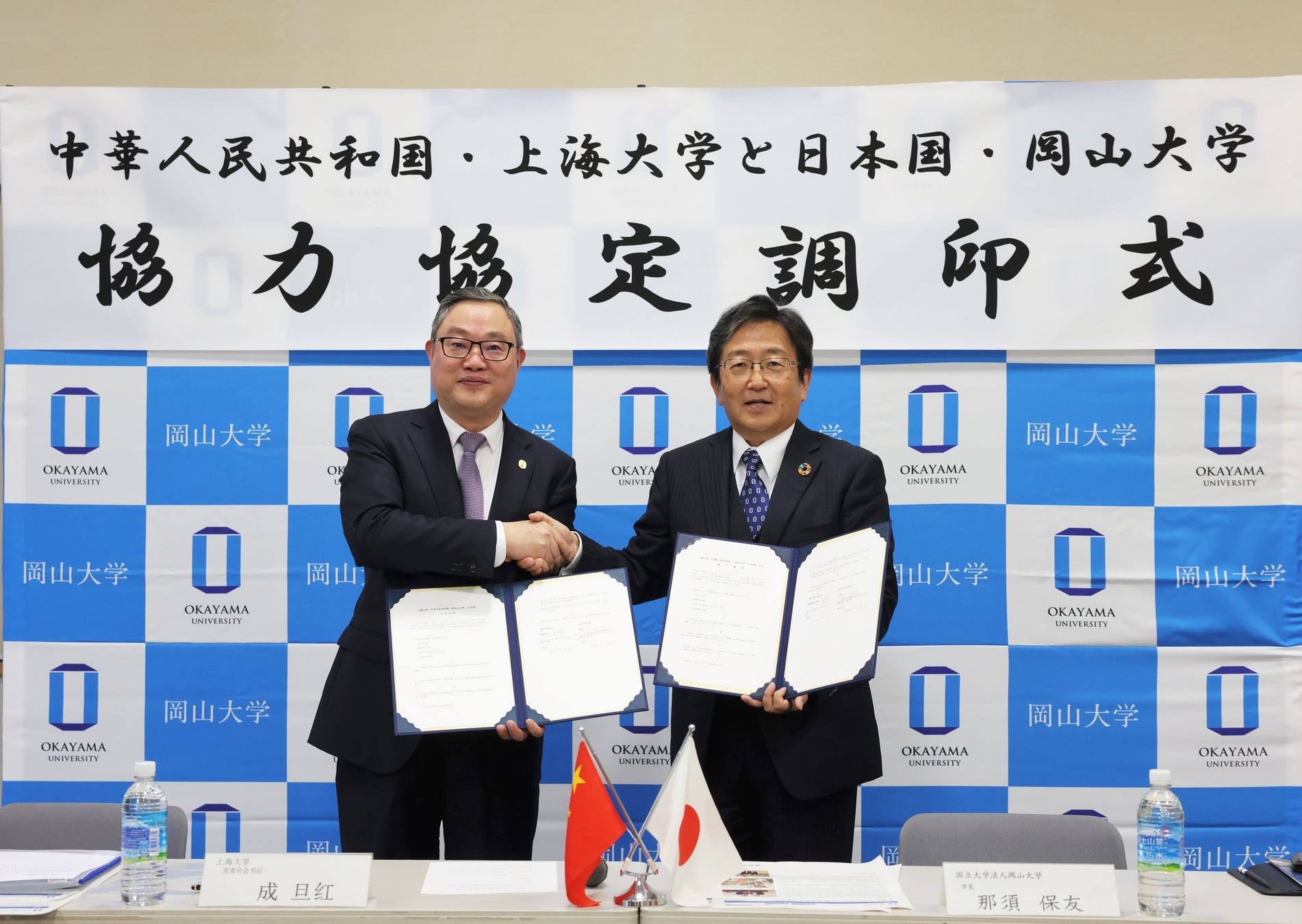 調印後に成党委員会書記と握手を交わす那須学長