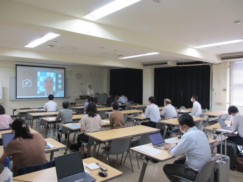 岡山大学総合技術本部長・監修教員の佐藤法仁副理事・副学長（オンライン）のあいさつを聞く参加者ら