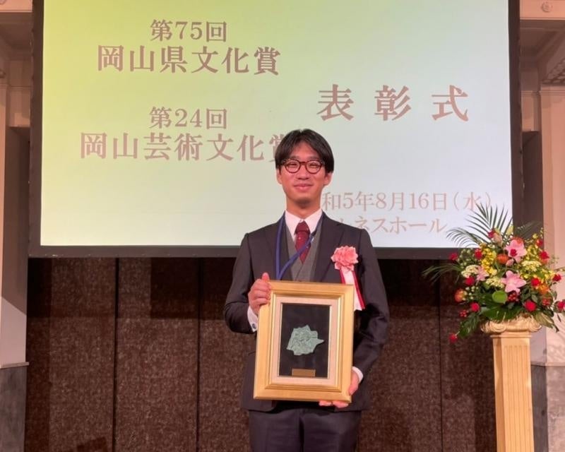 表彰盾を手にする河合穂高研究准教授