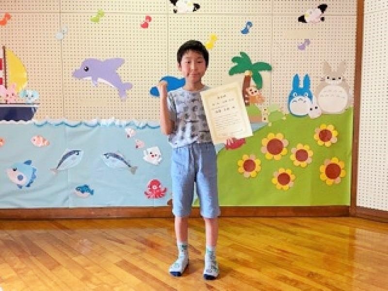 賞状を手にガッツポースをする佐藤さん