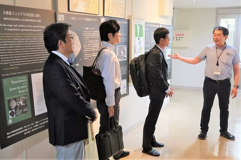 小惑星リュウグウの起源と進化について説明をする小林教授（右から小林教授、林審議官、奥原子力課長、那須学長）