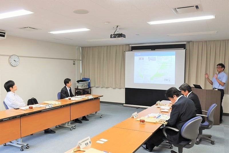 惑星物質研究所の概要説明を行う芳野所長（右）