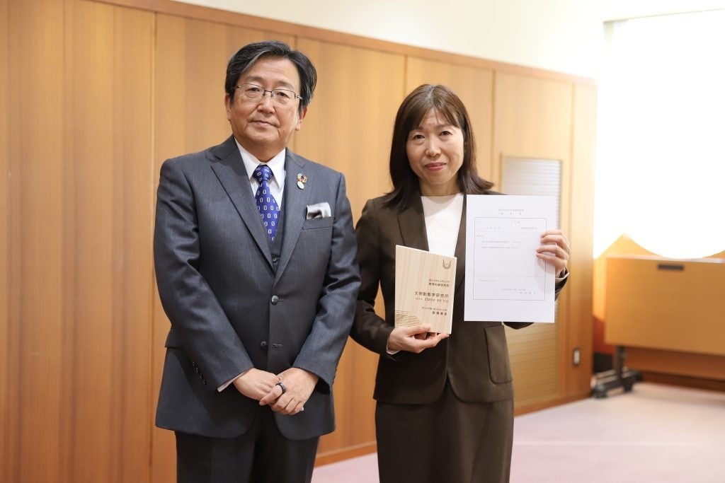 岡山大学高等先鋭研究院の認定証と任命書を持つ松本直子所長と那須保友学長(左)