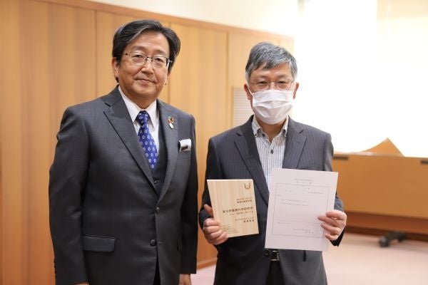 岡山大学高等先鋭研究院の認定証と任命書を持つ沈建仁所長と那須保友学長（左）
