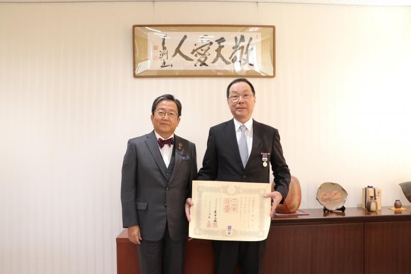 勲章を胸に、章記を持つ佐藤教授（右）