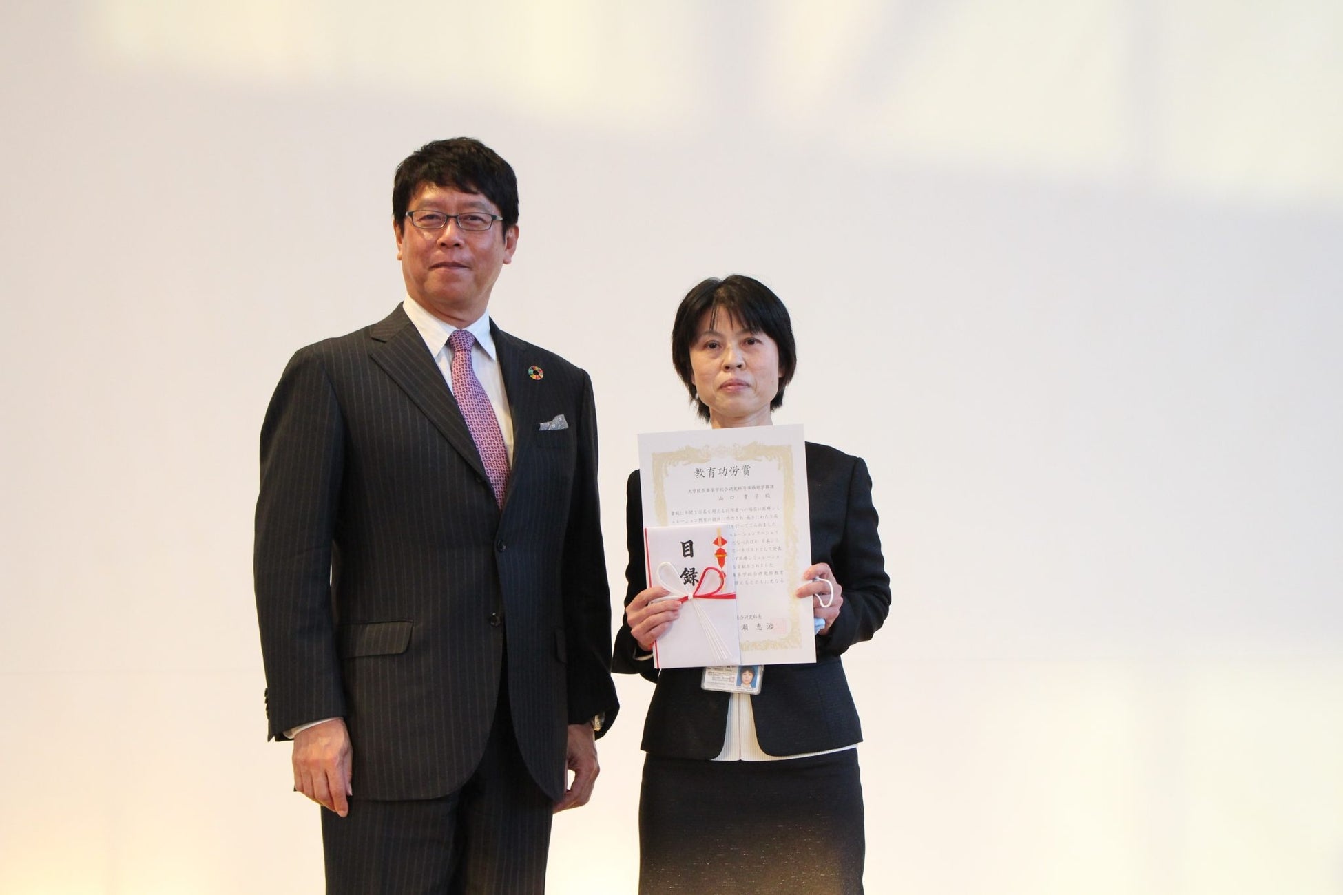 受賞者の山口事務職員と成瀬研究科長(左)