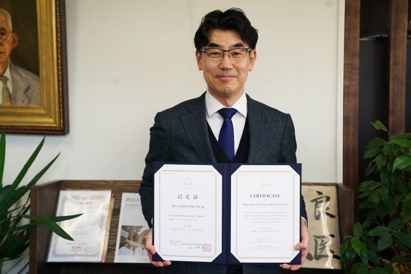認定証を手にする豊岡医学部長