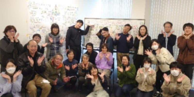 記念写真（背景のイラスト3点はグラフィックレコードの成果）