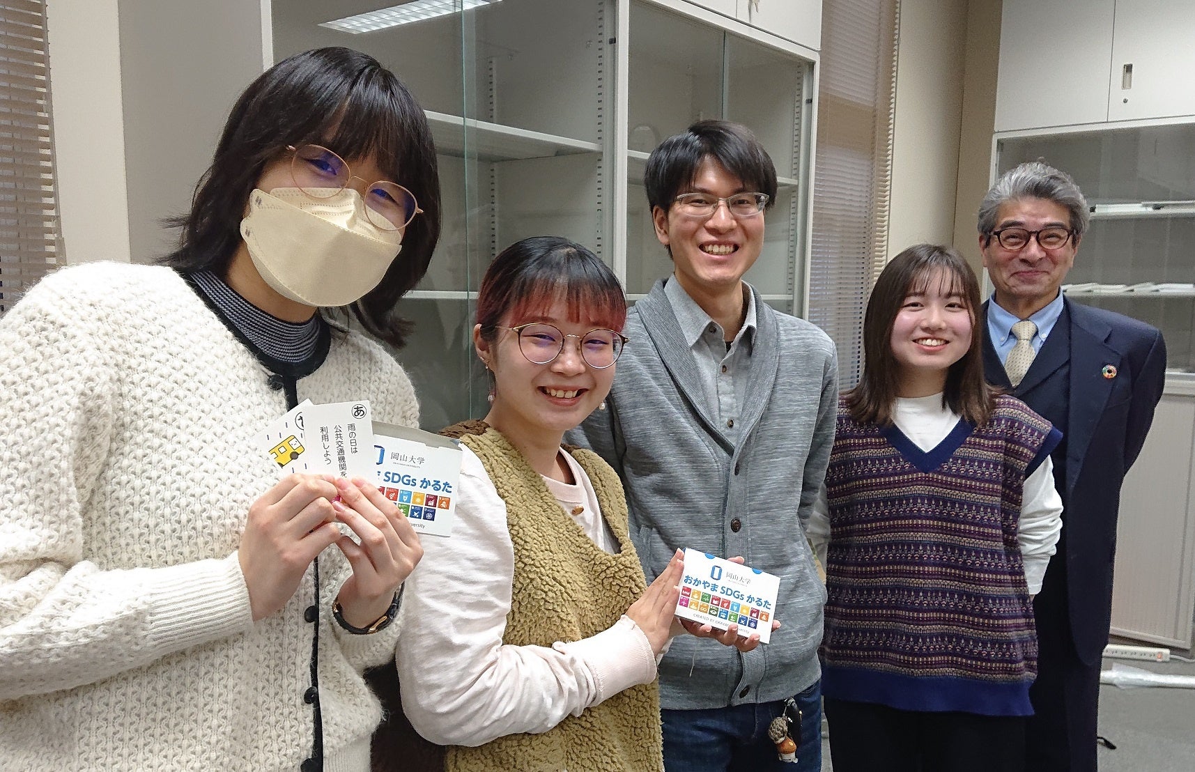 おかやまSDGsかるたを手に岡山大学TFTメンバーらとの記念撮影（左から中村さん、土井さん、中澤さん、澁谷さん、町田准教授）