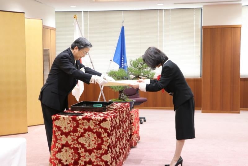 那須学長（左）から称号証を受ける名誉教授