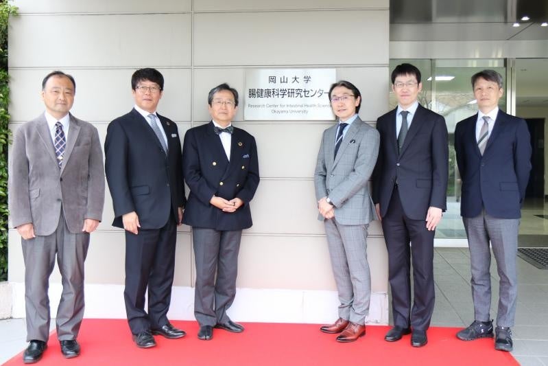 記念撮影（左から三好副センター長、成瀬センター長、那須学長、大塚文男教授、大塚基之教授、上原孝薬学部長）