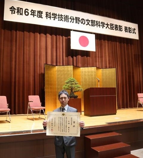 表彰状を手にする仁科教授