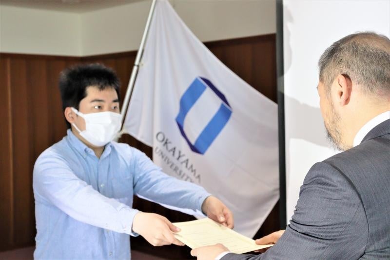 畑中本部長から認定証を授与される学生セミマイスター(左)