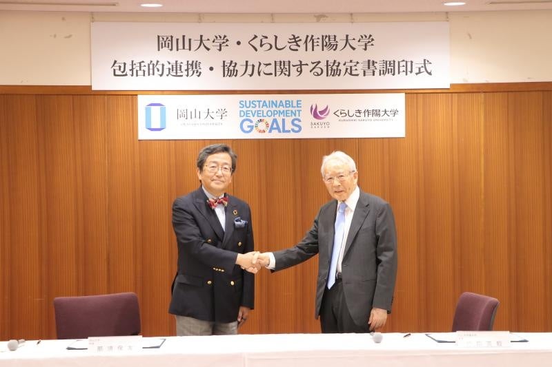 那須学長(左)と松田学長の握手