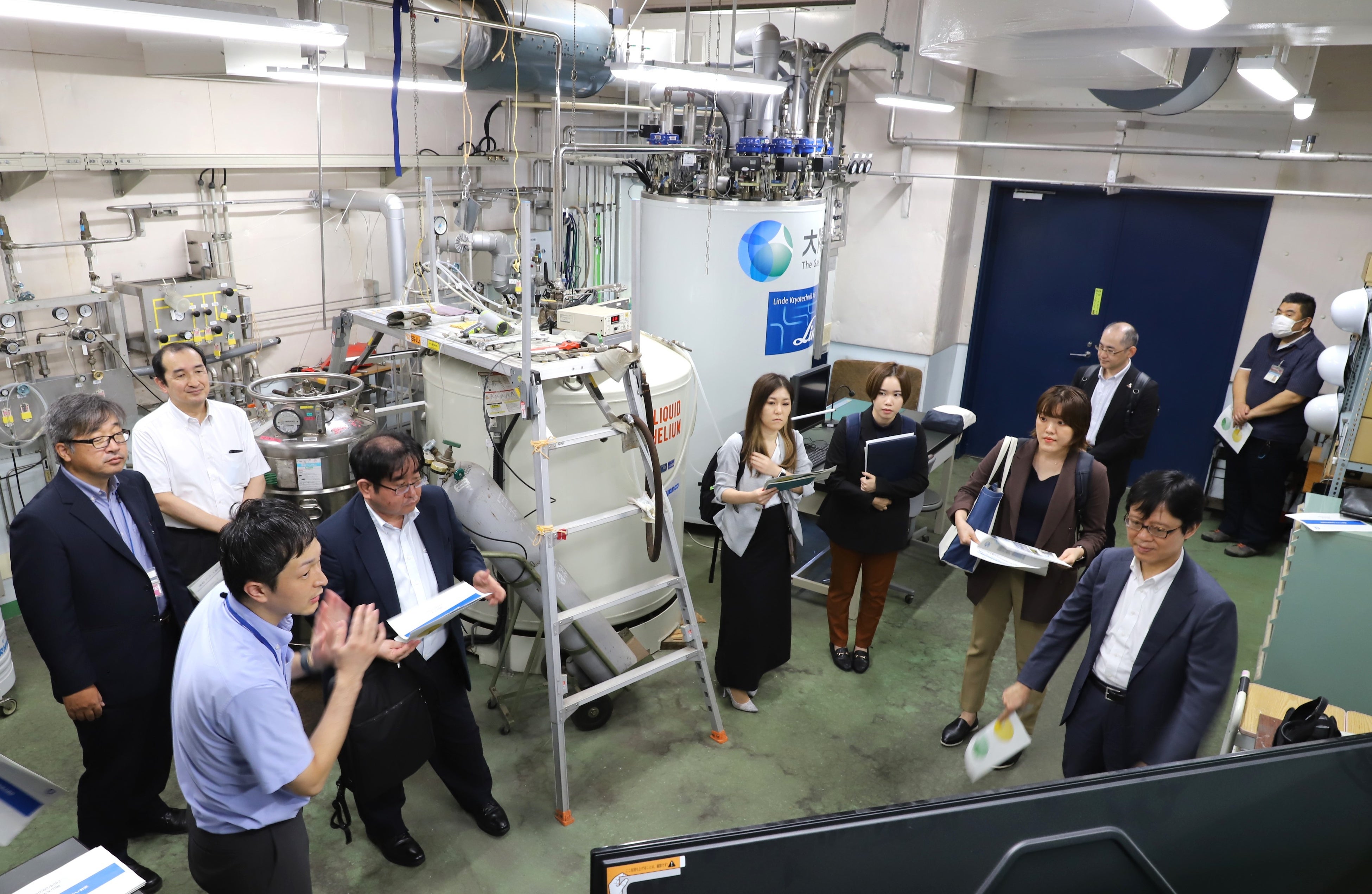 ヘリウム供給拠点構想について説明する松本副本部長（左）