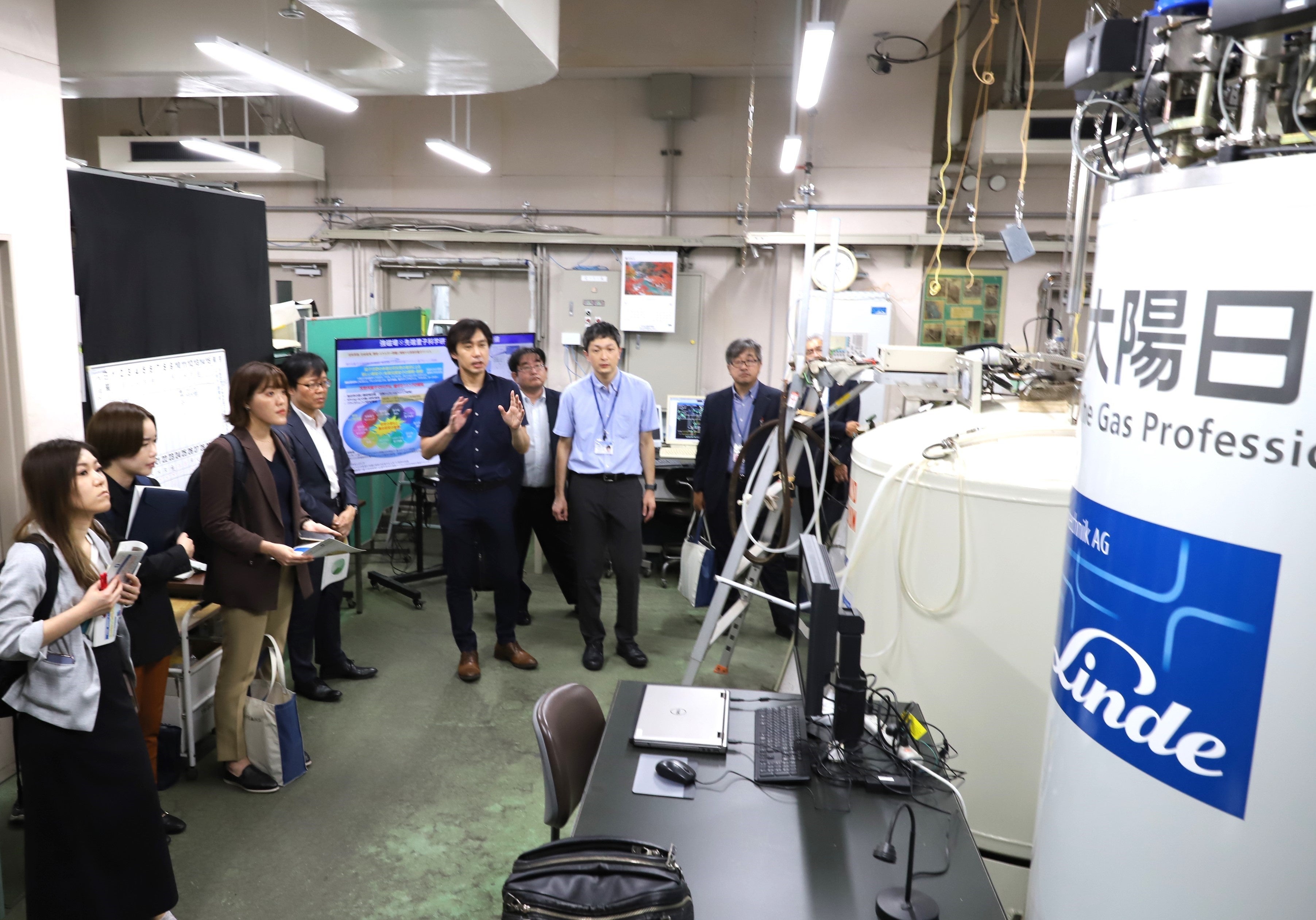 本学のヘリウム供給について説明する笠原教授（左から5人目）