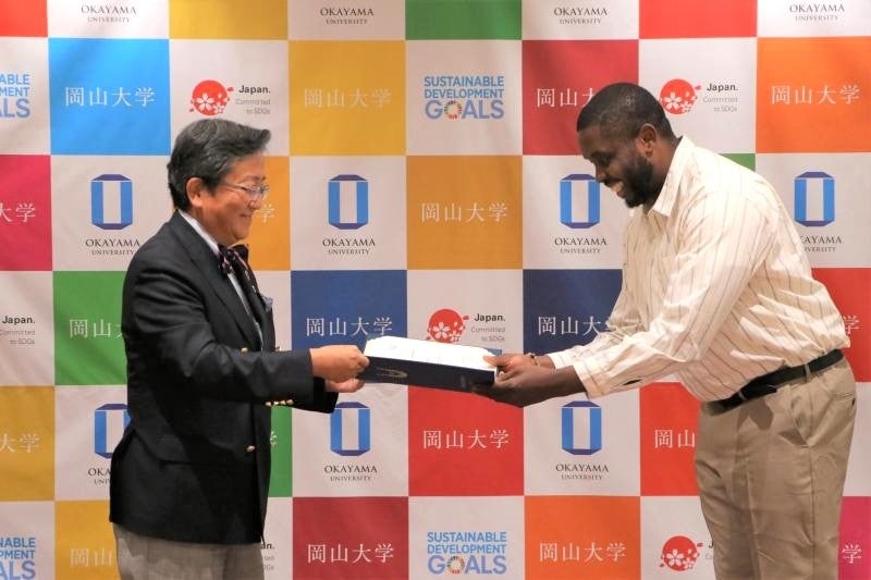 修了証書を授与する那須学長(左)とチゴジーさん(右)