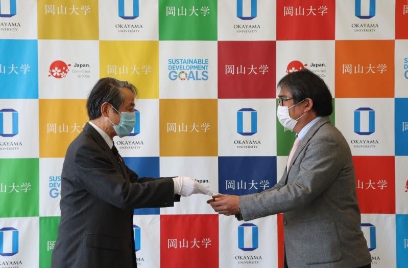 槇野学長から認定盾を授与される代表者（右）