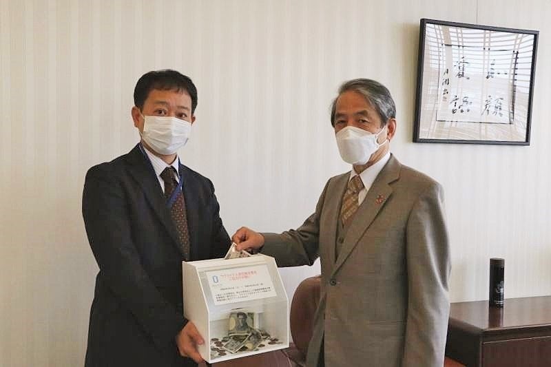 募金箱へ寄付をする槇野博史学長(右)