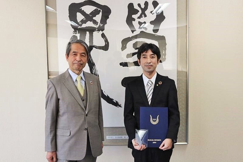 槇野博史学長（左）より表彰を受けた増田孝彦特任准教授