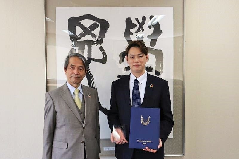 槇野博史学長(左)より表彰を受けた齋藤圭介准教授