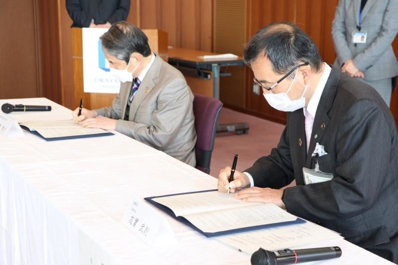 協定書に署名する槇野学長(左)と友實市長