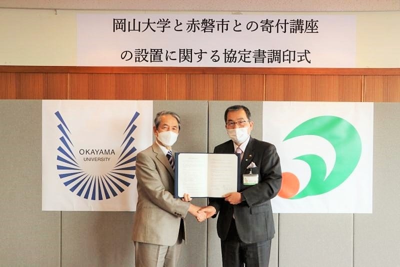 握手を交わす槇野学長と友實市長