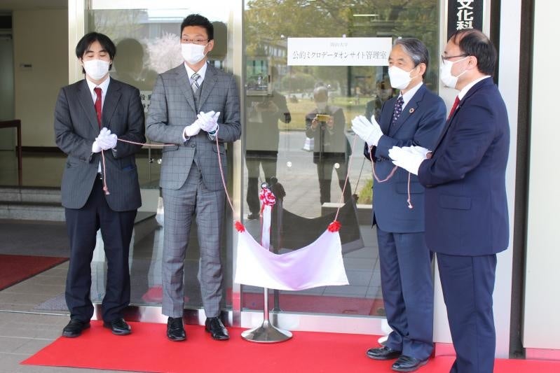 看板を除幕する槇野学長ら