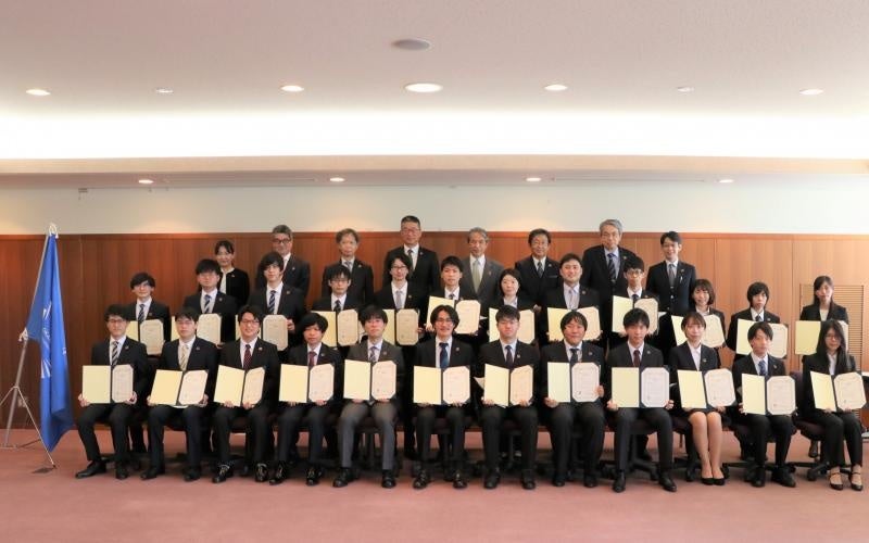 認定者・関係者による記念撮影（前列・中央列：認定者、後列：関係者（中央が槇野学長））※写真撮影時のみマスクを外しました