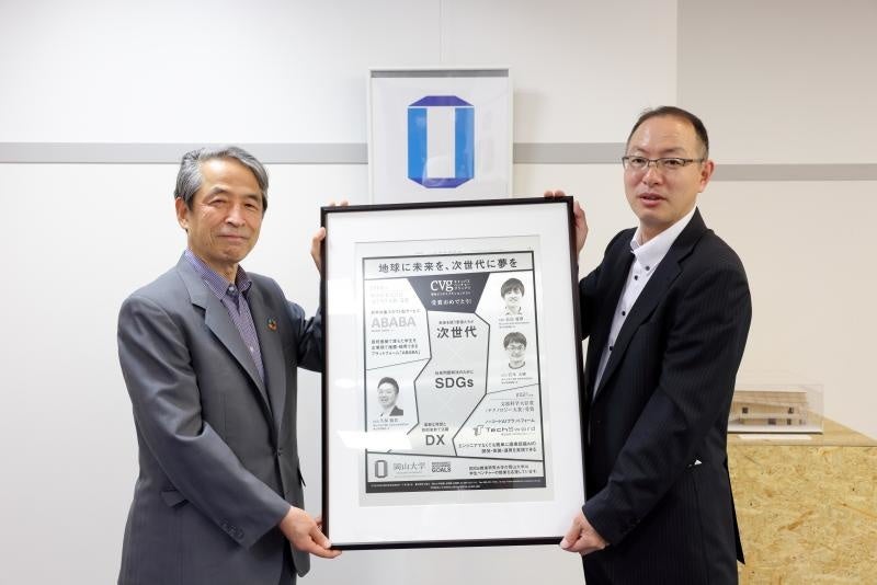記念額装を槇野学長に手渡す金井担当部長(右)※撮影時のみマスクを外しました