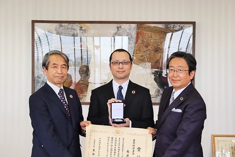 メダルを手にする長尾遼特任講師（中央）（左：槇野学長、右：那須理事）※撮影時のみマスクを外しました