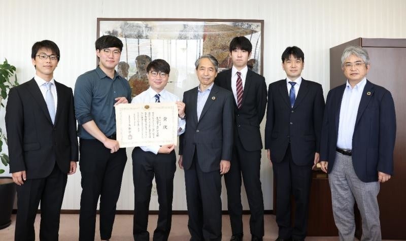 記念写真（左から、佐治さん、Kangさん、芝さん、槇野学長、戎さん、山内教授、菅工学部長）※撮影時のみマスクを外しました