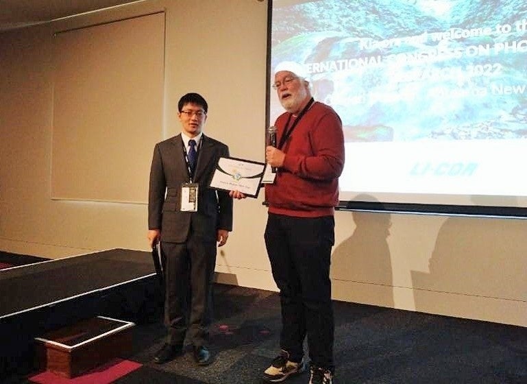 国際光合成学会会長のWim VERMAAS教授（右）より賞状を授与される菅倫寛教授（左）