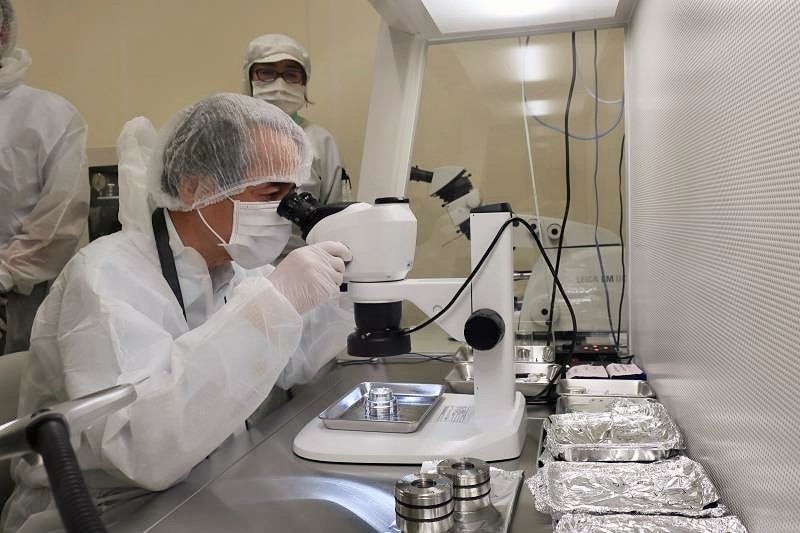 小惑星リュウグウの試料を実体顕微鏡で観察する槇野学長