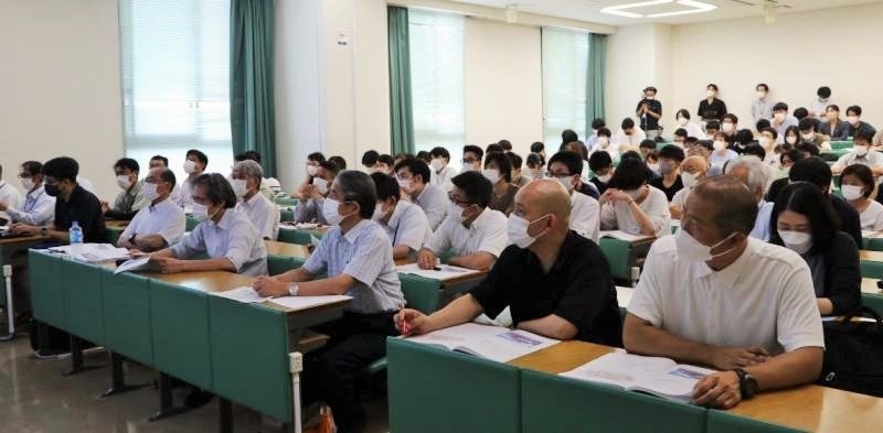講演に聞き入る参加者ら（前列右から3人目が槇野学長、4人目が阿部理事）