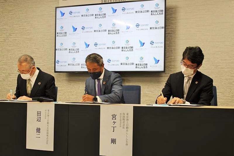 協定書に調印する関係者