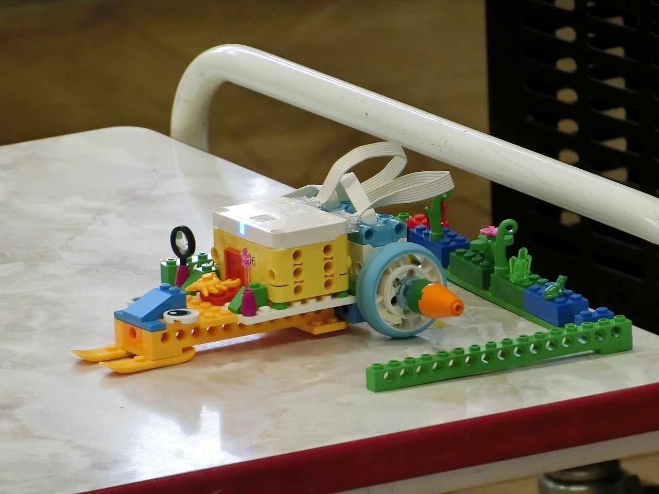 前のスコップで一定の高さ以上となった雑草を刈り、所定の場所まで運ぶシステム