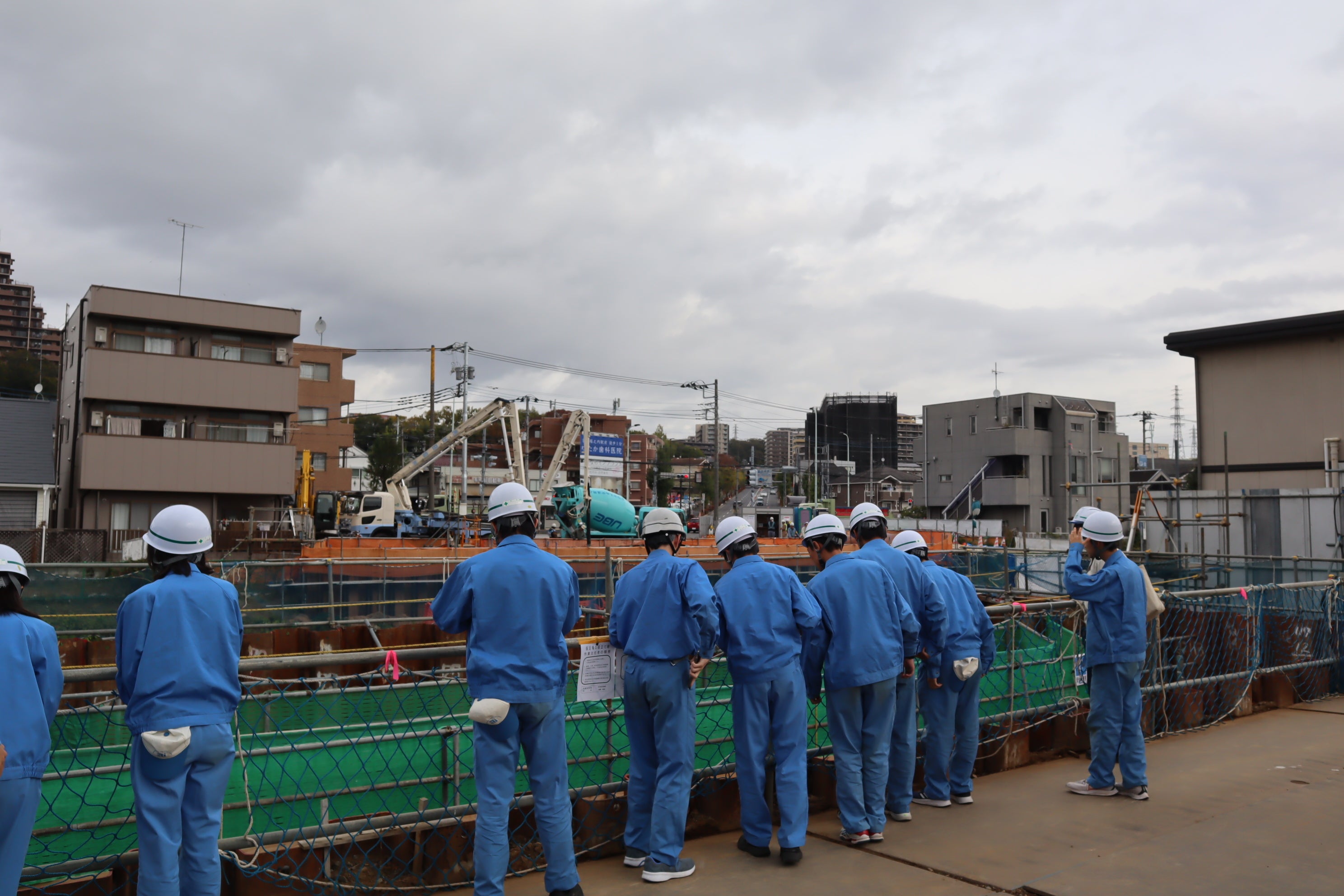 進行中の橋梁工事の様子を見学する生徒たち（橋の町田市側には多摩ニュータウン通り）