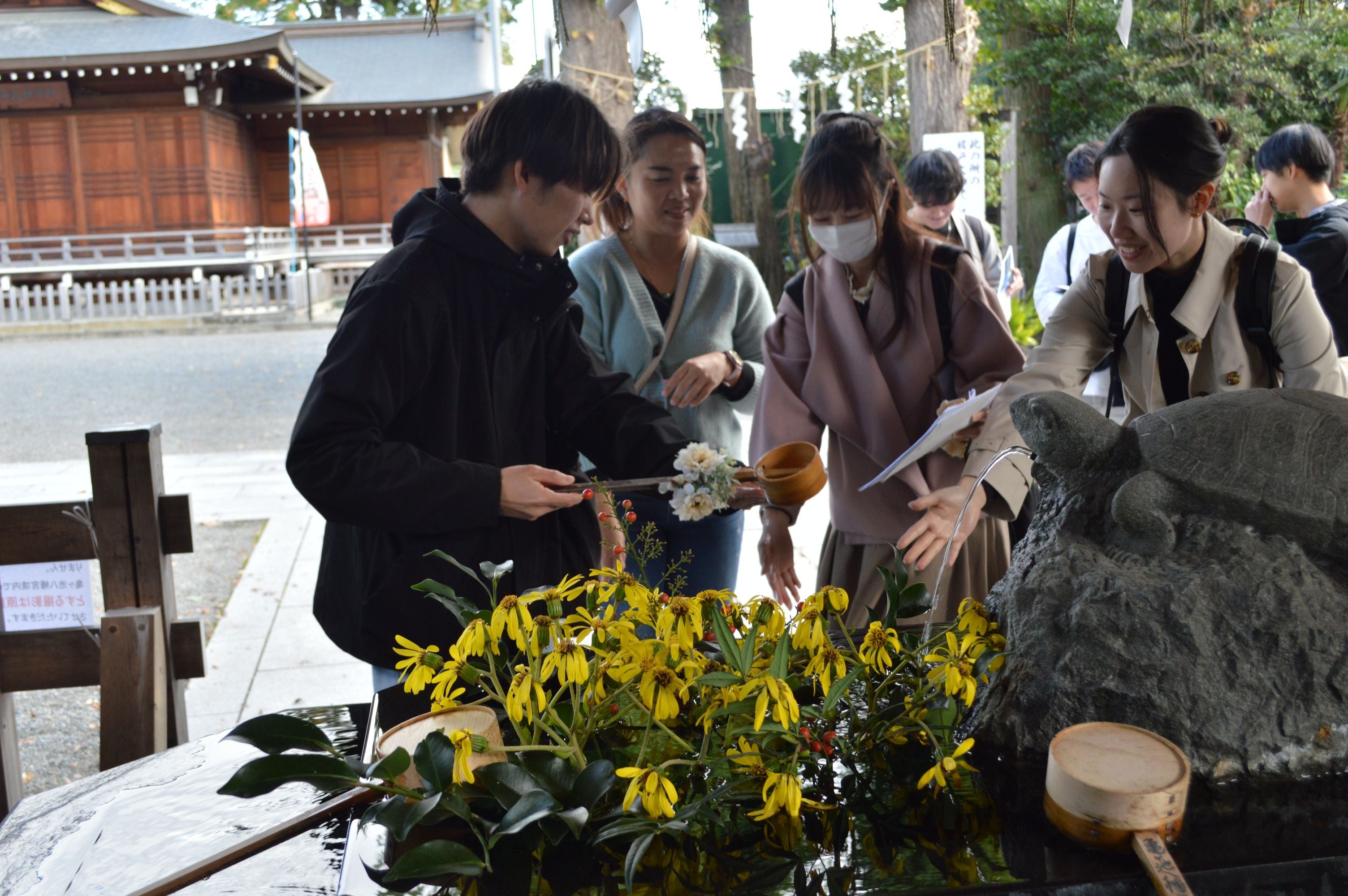 主催した学生からの説明を受け、手水の正しい作法を学ぶ