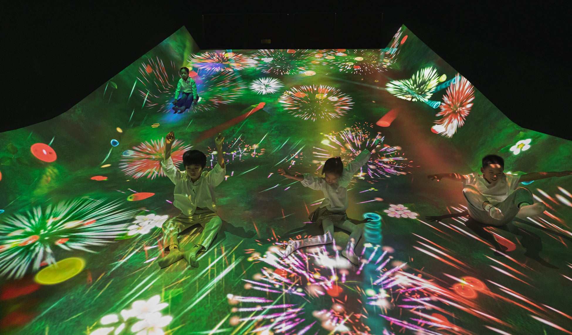 さまざまなフルーツが育つすべり台。坂には、いろいろなフルーツが育っている。そして、ボールが飛びまわっている。チームラボ《すべって育てる! フルーツ畑》© チームラボ