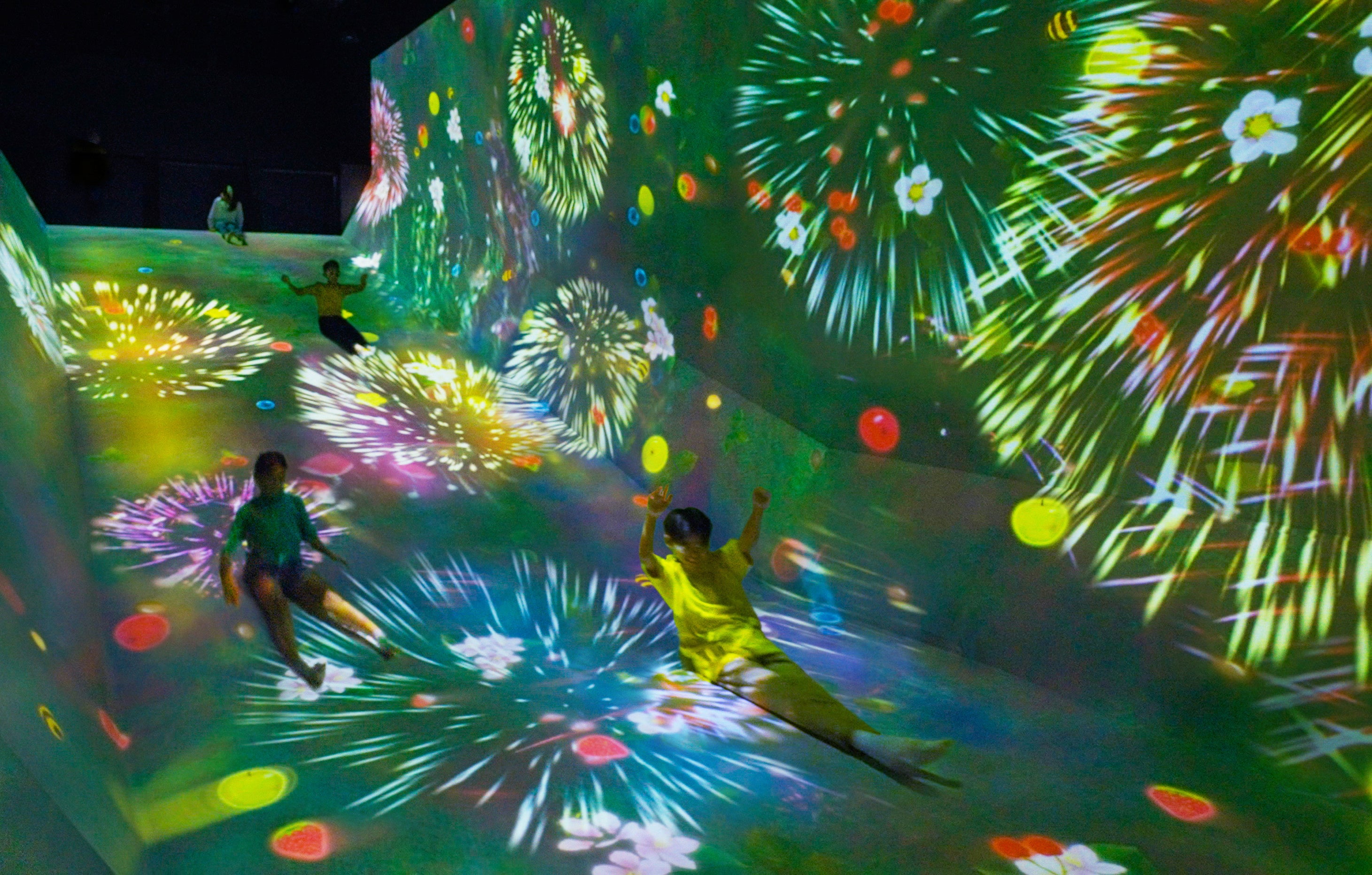 体がボールにぶつかると、太陽の光のエネルギーをもらったボールは、勢いよく飛んでいきます。チームラボ《すべって育てる！フルーツ畑》© チームラボ