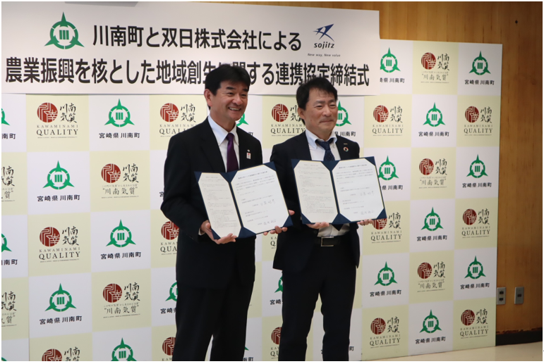 【調印式：左から川南町日髙 昭彦町長、湯浅 裕司 双日執行役員 生活産業・アグリビジネス本部長】
