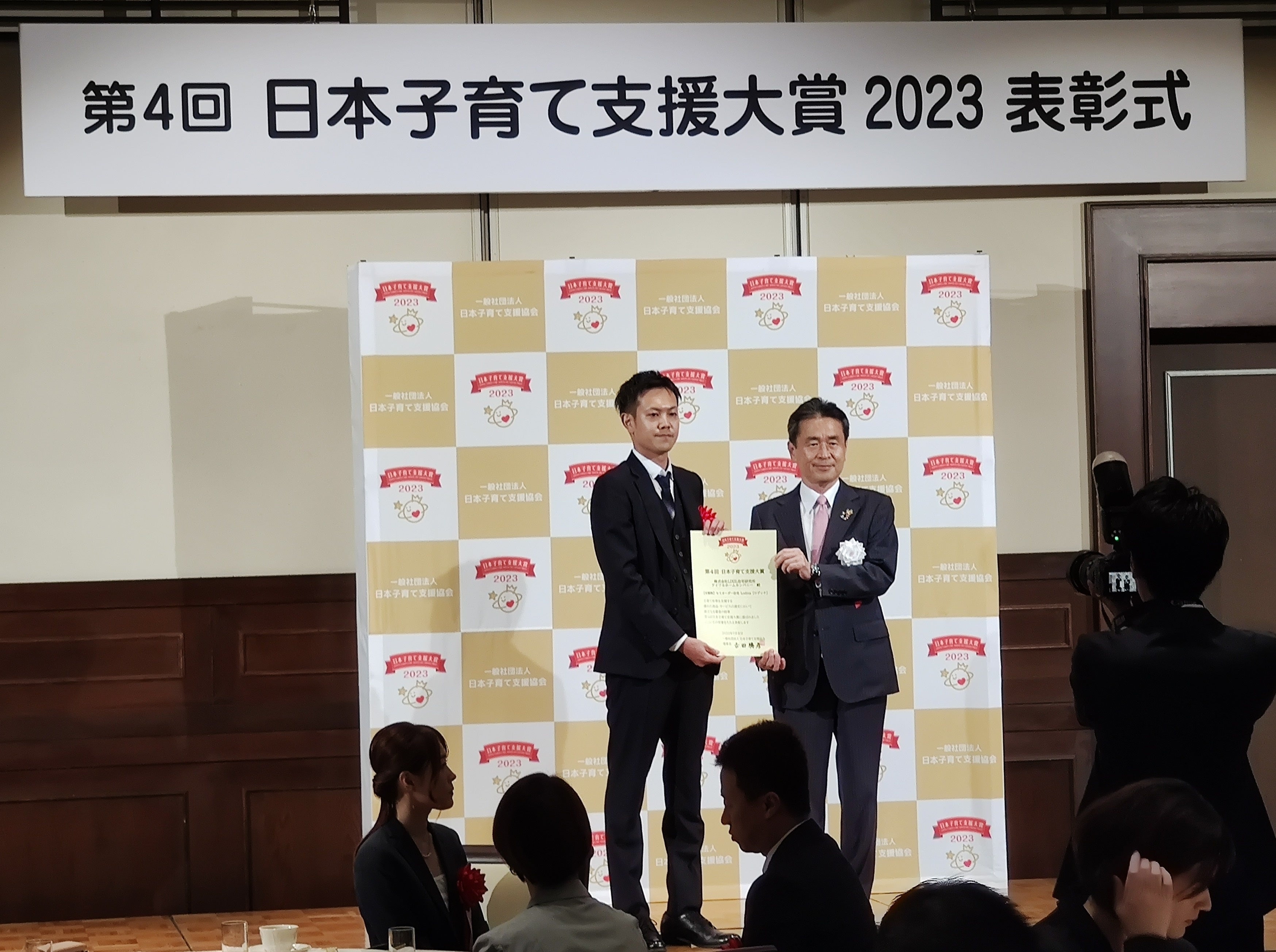 2023年7月19日に行われた表彰式の様子 (左)商品部 山口 壮太  (右)日本子育て支援協会 理事長 吉田 勝彦 氏