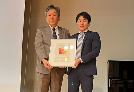 表彰式の様子（右が立花卓巳さん、左は日本風工学会・奥田泰雄会長)