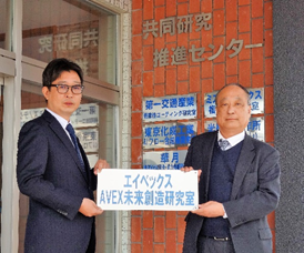 k-Team開設式にて設置する銘板を掲げる竹茂校長 　と加藤代表取締役社長