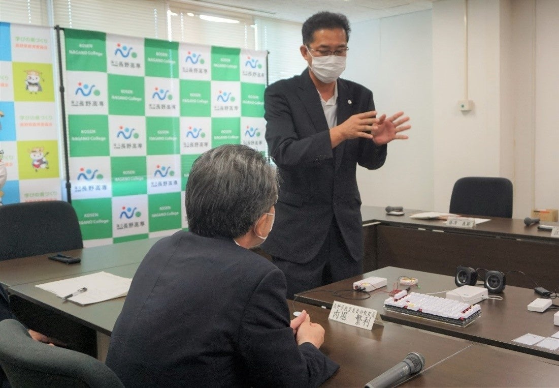 内堀教育長に長野高専GEAR5.0プロジェクトで開発した支援機器について藤澤教授から説明をしている様子