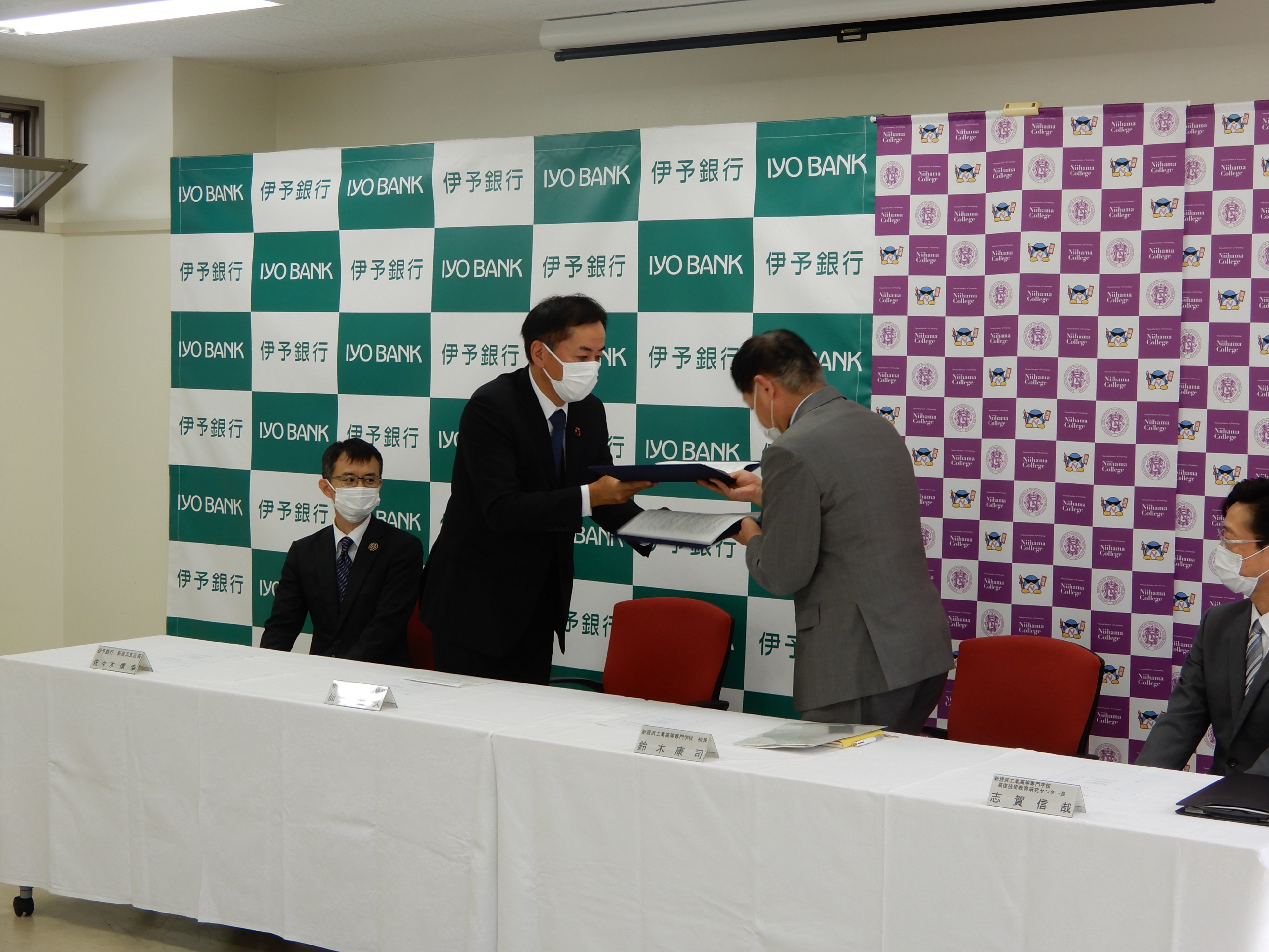 協定書を取り交わす鈴木校長と仙波常務取締役